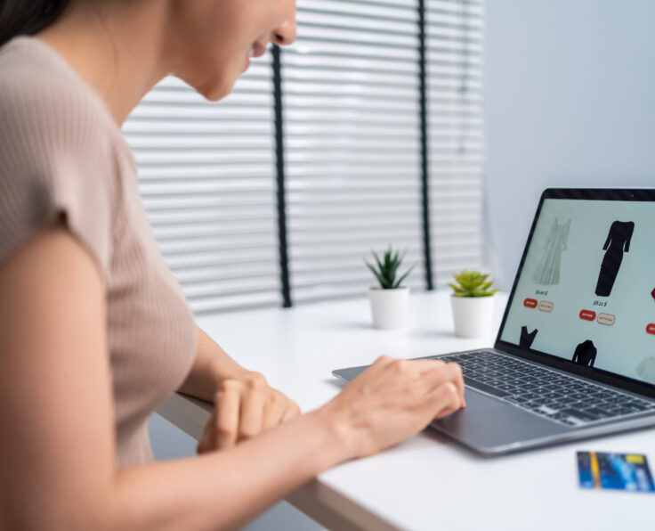 Asian young woman use laptop computer for shopping product sell online. Attractive beautiful girl holding credit card in hands buying and purchase goods on website in smartphone. E-commerce concept.